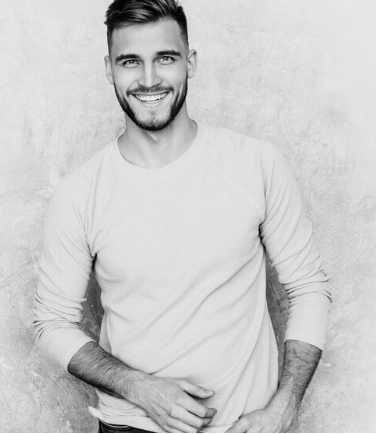 Photo en noir et blanc d'un jeune homme souriant aux cheveux courts